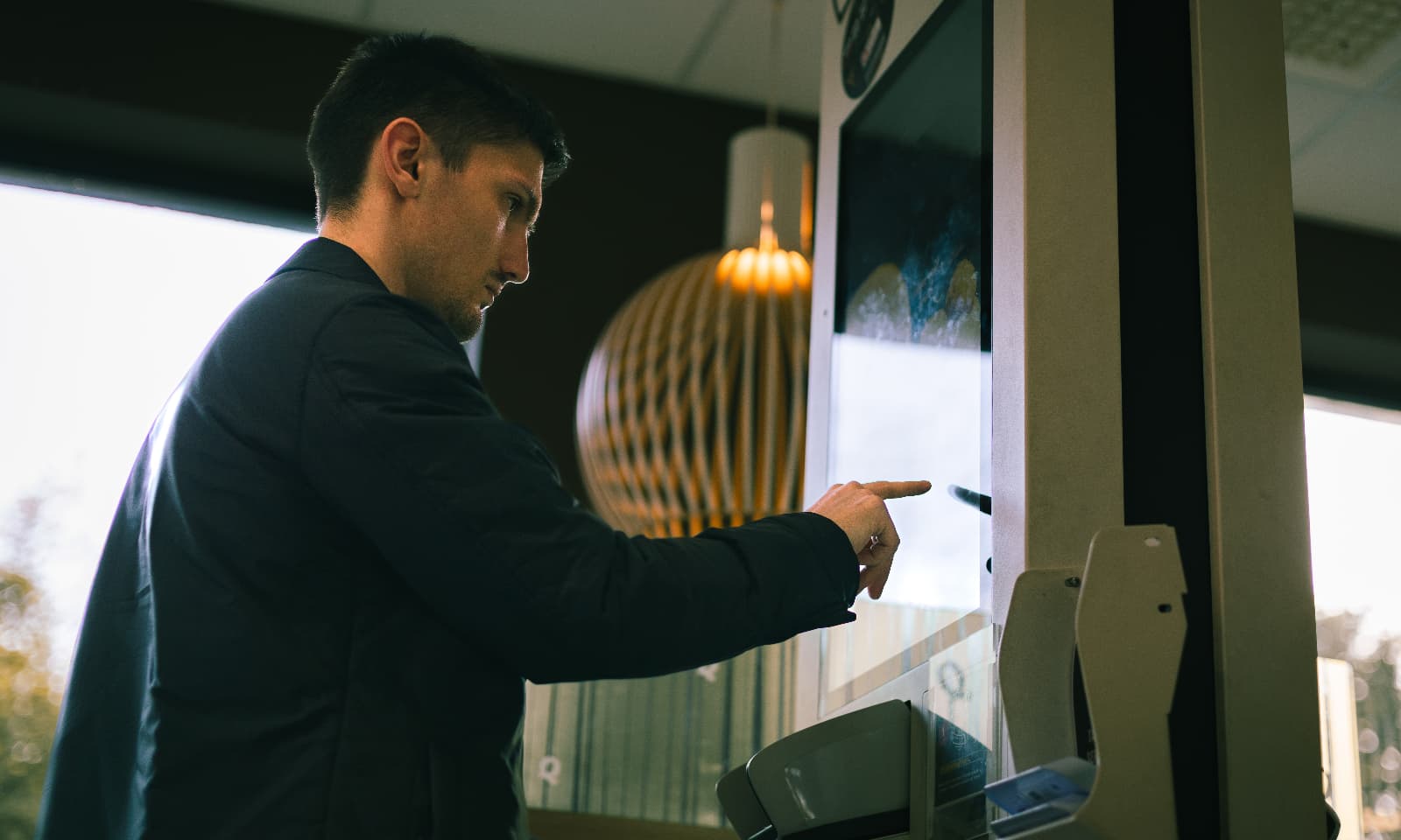 Man makes an order for fast food on an electronic menu board