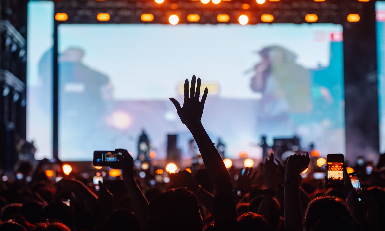 Crowd watching a live performance on a large outdoor LED screen at a concert, demonstrating high-impact visual displays for festivals, live events and public gatherings.